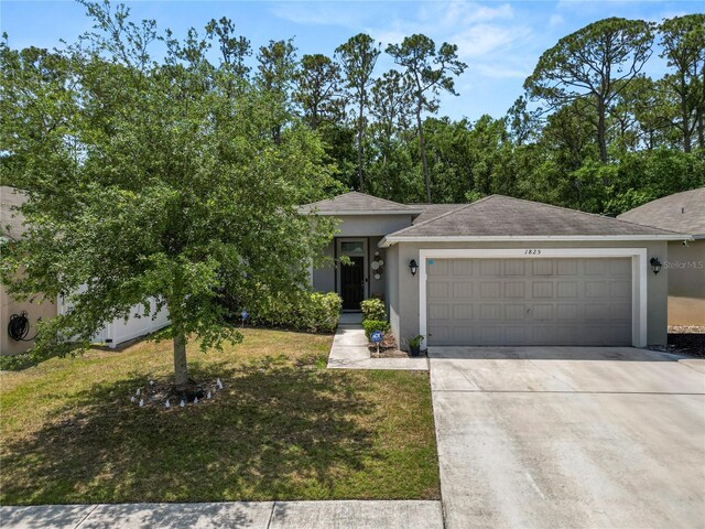 1825 Wallace Manor Ln, Winter Haven, FL 33880 - view of front of house with stucco siding, an attached garage, driveway, and a front lawn