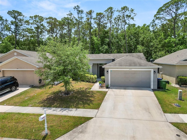 1825 Wallace Manor Ln, Winter Haven, FL 33880 - view of front of property with an attached garage, concrete driveway, stucco siding, and a front yard