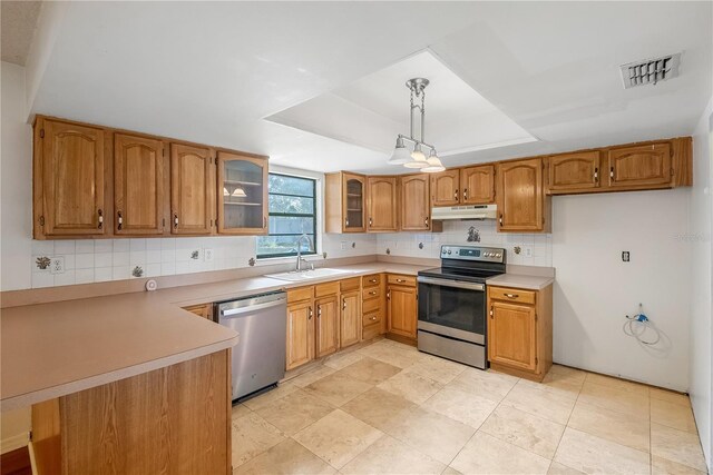 120 Bolender Rd, Auburndale, FL 33823 - kitchen featuring stainless steel appliances, a sink, under cabinet range hood, brown cabinetry, and backsplash
