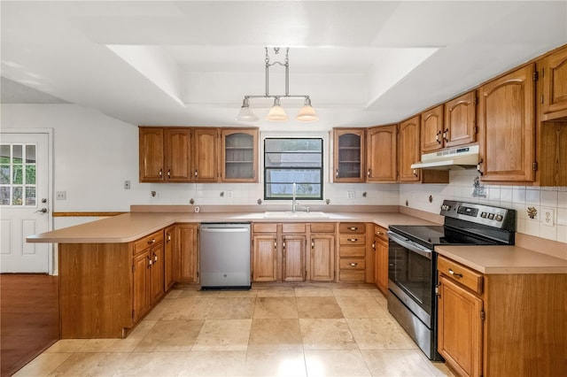 120 Bolender Rd, Auburndale, FL 33823 - kitchen featuring appliances with stainless steel finishes, under cabinet range hood, a tray ceiling, a peninsula, and a sink