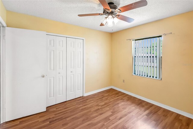 120 Bolender Rd, Auburndale, FL 33823 - unfurnished bedroom with wood finished floors, a closet, a textured ceiling, baseboards, and a ceiling fan
