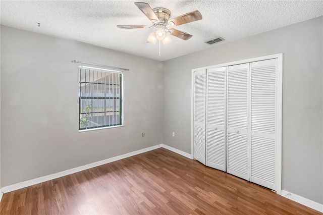 120 Bolender Rd, Auburndale, FL 33823 - unfurnished bedroom with wood finished floors, baseboards, a closet, a textured ceiling, and ceiling fan