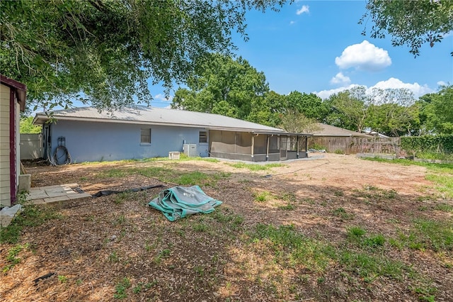 120 Bolender Rd, Auburndale, FL 33823 - rear view of property featuring a sunroom, metal roof, stucco siding, and fence