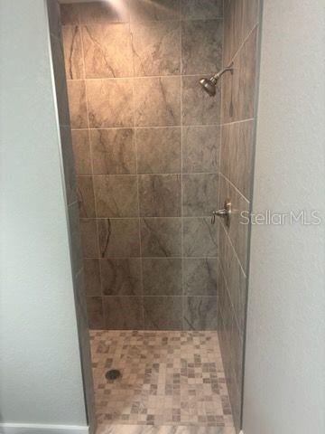 bathroom featuring a stall shower and baseboards