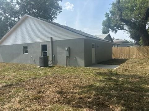 rear view of property featuring central AC and stucco siding