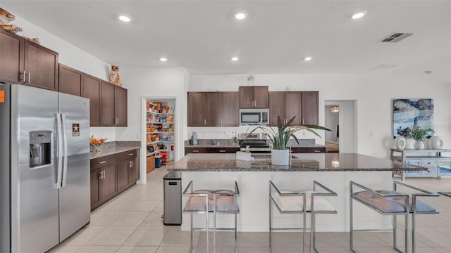 2991 Flying Blackbird Rd, Bartow, FL 33830 - kitchen featuring appliances with stainless steel finishes, a breakfast bar area, recessed lighting, dark brown cabinetry, and dark stone countertops