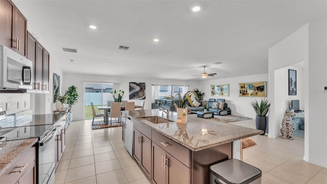 2991 Flying Blackbird Rd, Bartow, FL 33830 - kitchen featuring a sink, appliances with stainless steel finishes, open floor plan, a kitchen island with sink, and light tile patterned floors