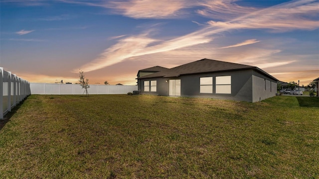 2991 Flying Blackbird Rd, Bartow, FL 33830 - back of property at dusk featuring stucco siding, a shingled roof, and central AC