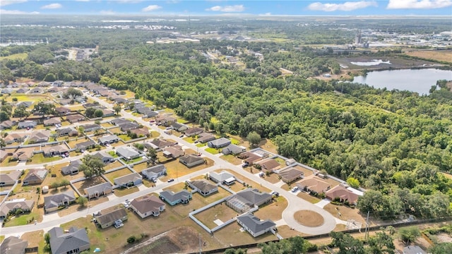 aerial view of property and surrounding area featuring a large body of water and a heavily wooded area