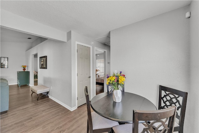dining space with light wood-style floors and baseboards