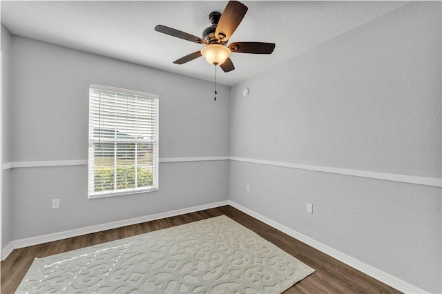 empty room with wood finished floors, ceiling fan, and baseboards