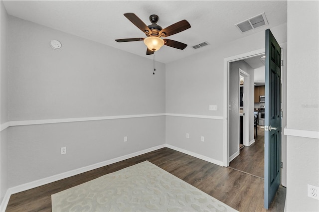 unfurnished room featuring ceiling fan, wood finished floors, and baseboards