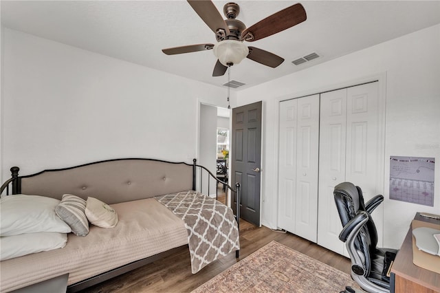 bedroom with wood finished floors, a closet, a ceiling fan, and a desk
