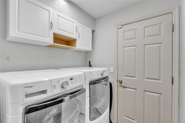 washroom featuring cabinet space and washing machine and clothes dryer