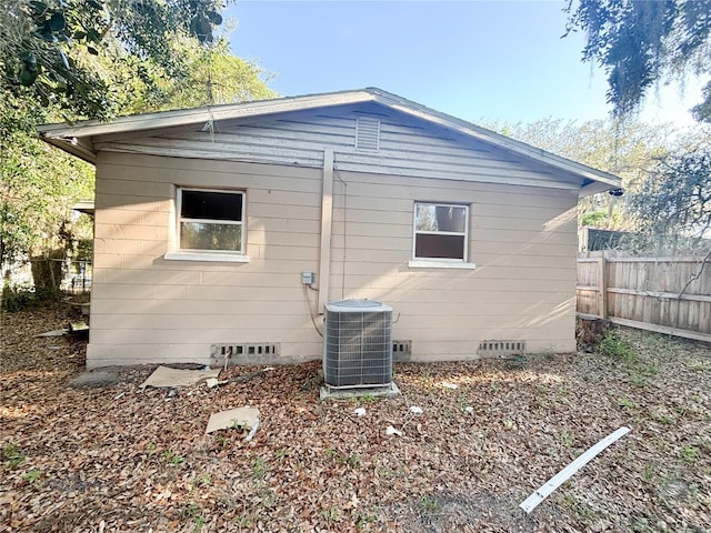 back of house featuring crawl space, cooling unit, and fence