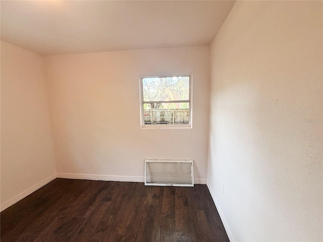 unfurnished room with dark wood-style flooring and baseboards