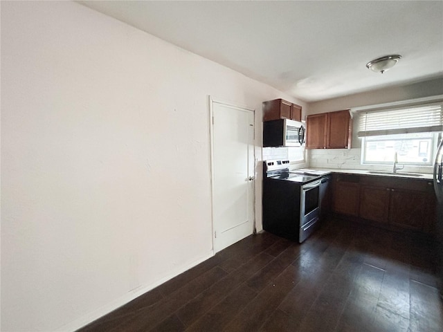 1160 Austin St, Bartow, FL 33830 - kitchen with stainless steel appliances, dark wood-style floors, a sink, decorative backsplash, and brown cabinets
