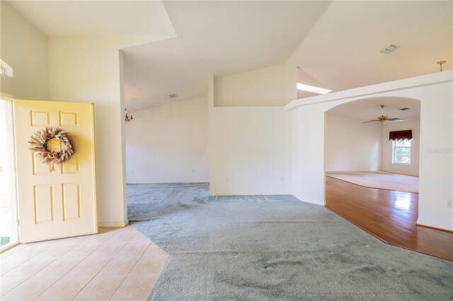 3798 N Chandler Dr, Hernando, FL 34442 - unfurnished room with light colored carpet, arched walkways, vaulted ceiling, a ceiling fan, and baseboards