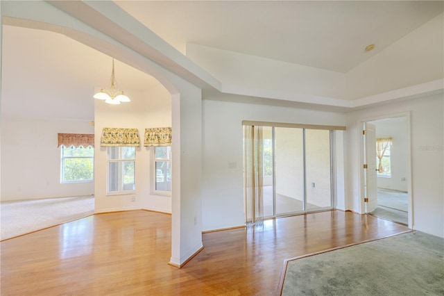 3798 N Chandler Dr, Hernando, FL 34442 - empty room with light wood-style flooring, a chandelier, arched walkways, baseboards, and vaulted ceiling