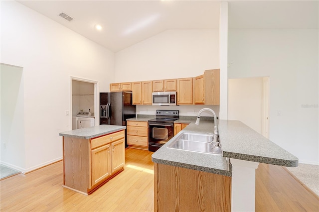 3798 N Chandler Dr, Hernando, FL 34442 - kitchen with black appliances, high vaulted ceiling, a sink, washer and clothes dryer, and light brown cabinetry