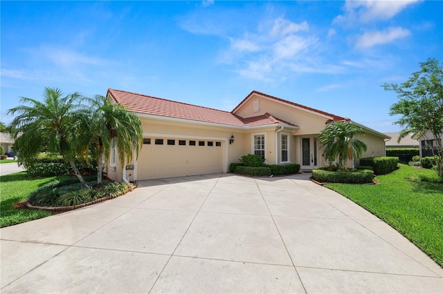 mediterranean / spanish-style house featuring a tile roof, an attached garage, concrete driveway, stucco siding, and a front lawn