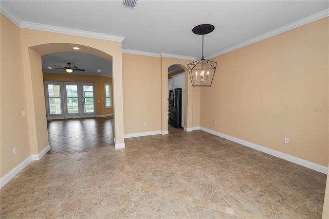 spare room with arched walkways, crown molding, a chandelier, ceiling fan, and baseboards
