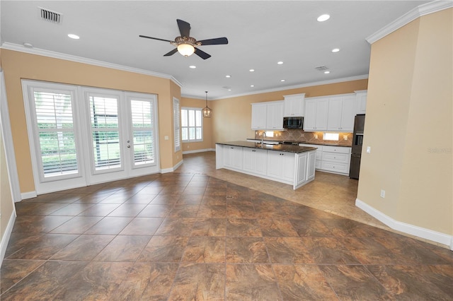 kitchen with dark countertops, baseboards, black refrigerator with ice dispenser, a ceiling fan, and ornamental molding