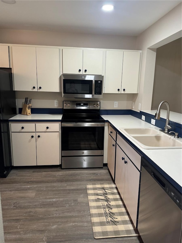 135 Wild Palm Dr, Bradenton, FL 34210 - kitchen featuring appliances with stainless steel finishes, a sink, white cabinetry, wood finished floors, and recessed lighting