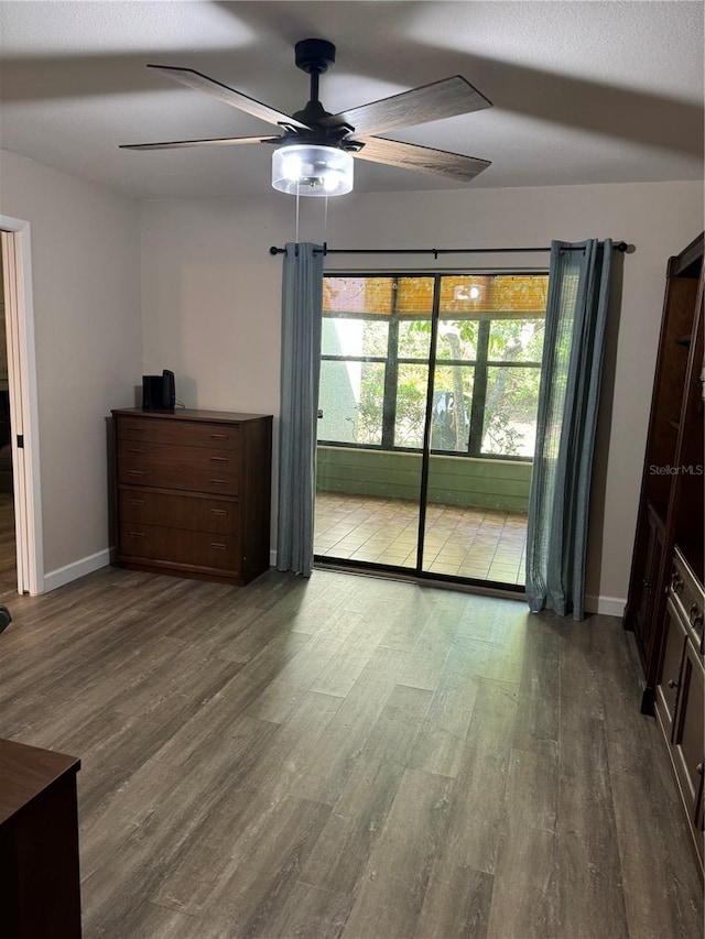 135 Wild Palm Dr, Bradenton, FL 34210 - unfurnished bedroom featuring wood finished floors, baseboards, a ceiling fan, and access to exterior