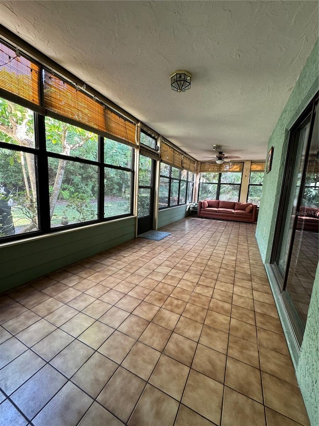 135 Wild Palm Dr, Bradenton, FL 34210 - unfurnished sunroom featuring ceiling fan, a textured ceiling, tile patterned floors, and plenty of natural light
