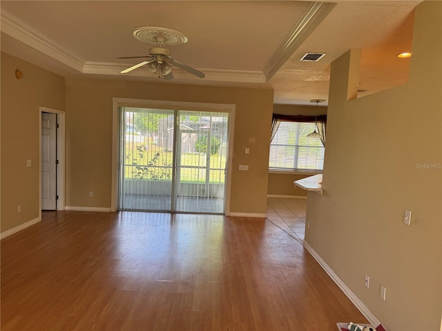 200 S Goodman Ave, Lake Alfred, FL 33850 - empty room with a ceiling fan, ornamental molding, a tray ceiling, baseboards, and wood finished floors