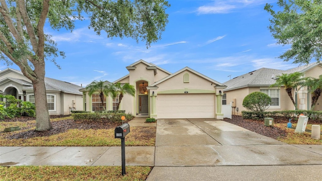 506 Henley Cir, Davenport, FL 33896 - view of front of home featuring stucco siding, a garage, and driveway