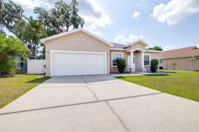 3281 Enclave Blvd, Mulberry, FL 33860 - view of front facade with stucco siding, driveway, a front yard, and an attached garage