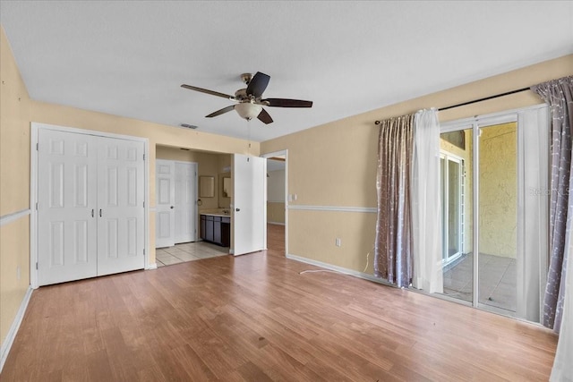 2173 Castle Pt, Winter Haven, FL 33880 - unfurnished bedroom featuring wood finished floors, access to exterior, baseboards, connected bathroom, and a ceiling fan