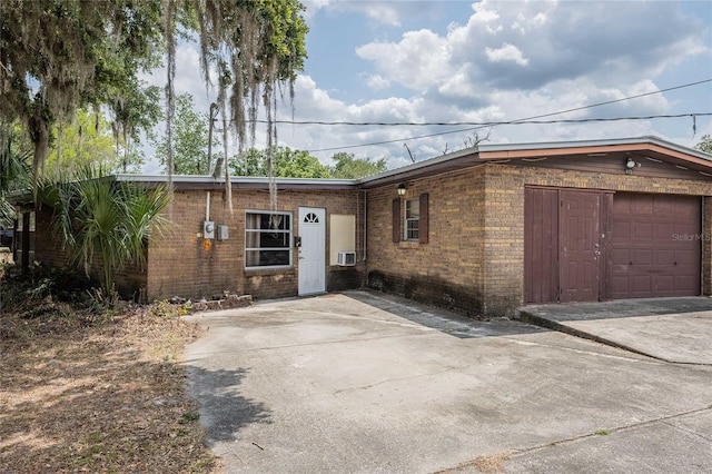 view of property exterior featuring brick siding, a garage, and driveway