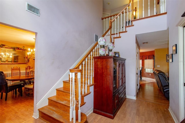 330 W Palmetto St, Lakeland, FL 33815 - staircase featuring a towering ceiling, wood finished floors, a chandelier, and baseboards