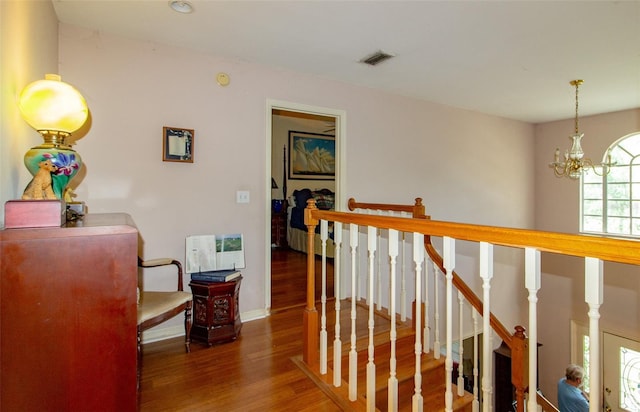 330 W Palmetto St, Lakeland, FL 33815 - corridor with wood finished floors, an upstairs landing, a chandelier, heating unit, and baseboards
