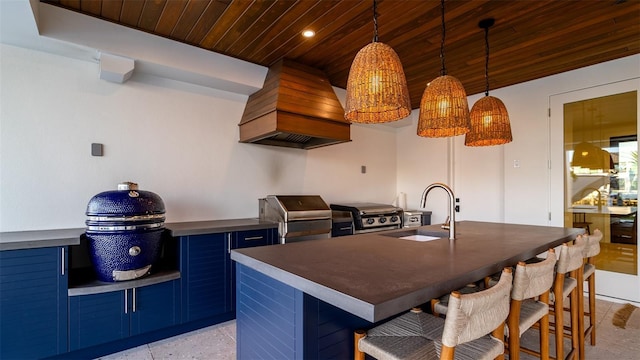 531 68th St, Holmes Beach, FL 34217 - kitchen featuring blue cabinetry, a sink, wooden ceiling, premium range hood, and dark countertops