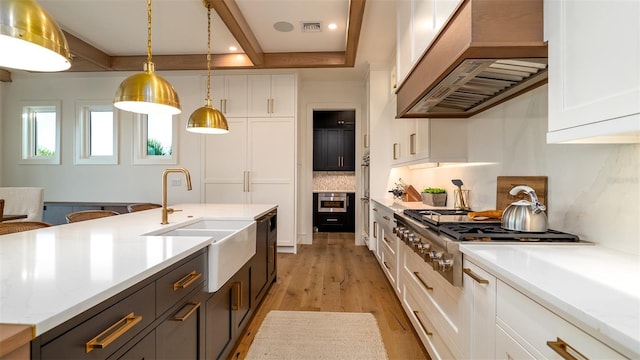 531 68th St, Holmes Beach, FL 34217 - kitchen featuring custom exhaust hood, white cabinets, stainless steel gas cooktop, backsplash, and a sink