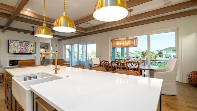 531 68th St, Holmes Beach, FL 34217 - kitchen featuring open floor plan, a sink, beam ceiling, light wood-style floors, and hanging light fixtures