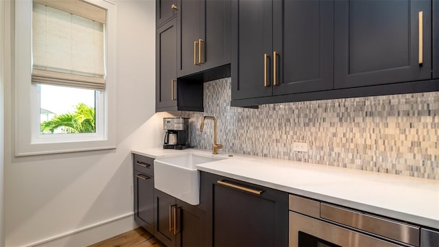531 68th St, Holmes Beach, FL 34217 - kitchen featuring a sink, decorative backsplash, light countertops, and wood finished floors