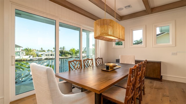 531 68th St, Holmes Beach, FL 34217 - dining room featuring beam ceiling, light wood-style flooring, coffered ceiling, baseboards, and a water view
