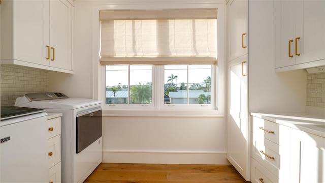531 68th St, Holmes Beach, FL 34217 - laundry room featuring cabinet space, washer and clothes dryer, and light wood-style floors