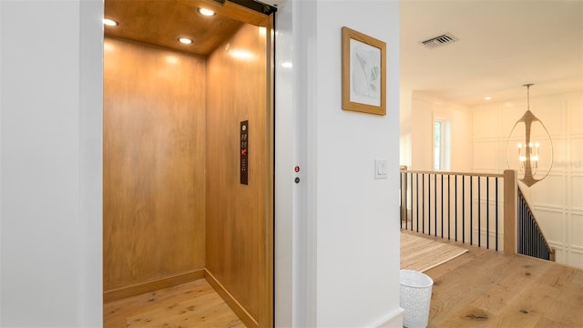 531 68th St, Holmes Beach, FL 34217 - hallway with elevator, light wood-style floors, recessed lighting, a chandelier, and an upstairs landing