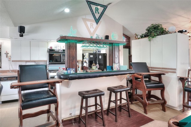 4404 Musket Dr, Lakeland, FL 33810 - indoor dry bar with black fridge with ice dispenser, vaulted ceiling, built in microwave, white dishwasher, and a textured ceiling