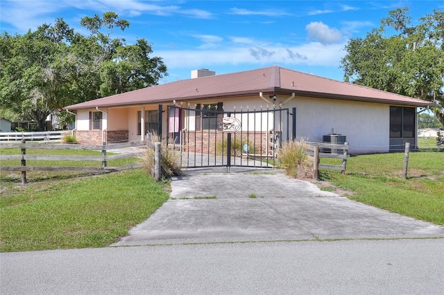 4404 Musket Dr, Lakeland, FL 33810 - view of front of house featuring driveway, a gate, metal roof, a chimney, and stucco siding