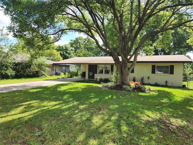 220 Pinehurst Dr, Auburndale, FL 33823 - ranch-style house featuring concrete driveway, an attached carport, and a front yard