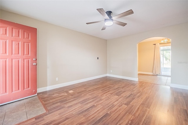 526 Marklen Loop, Polk City, FL 33868 - unfurnished room featuring arched walkways, light wood-type flooring, ceiling fan, and baseboards