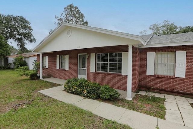 view of front of house with brick siding and a front lawn