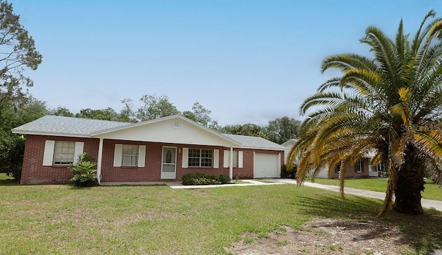 single story home with an attached garage, concrete driveway, a front yard, and brick siding